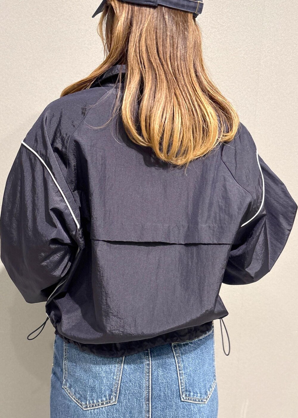 ブルー系のデニムスカート、ブルー系のブルゾン、ベージュ系のトレンチコートを着用したレディースの春コーディネートの6枚目の写真