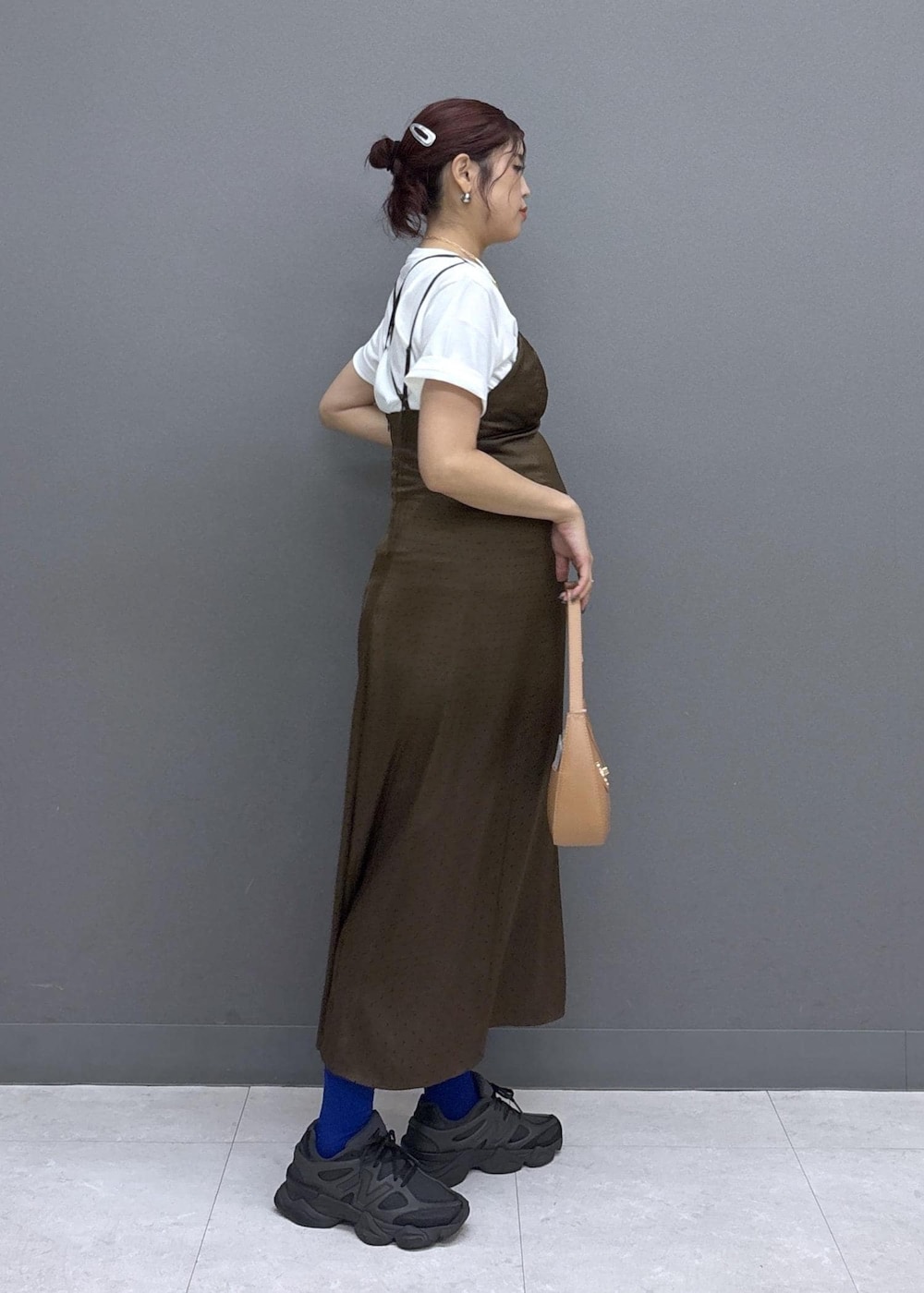 イエロー系のショルダーバッグ、ホワイト系のTシャツ/カットソー、ブラウン系のワンピースを着用したレディースの夏コーディネートの2枚目の写真