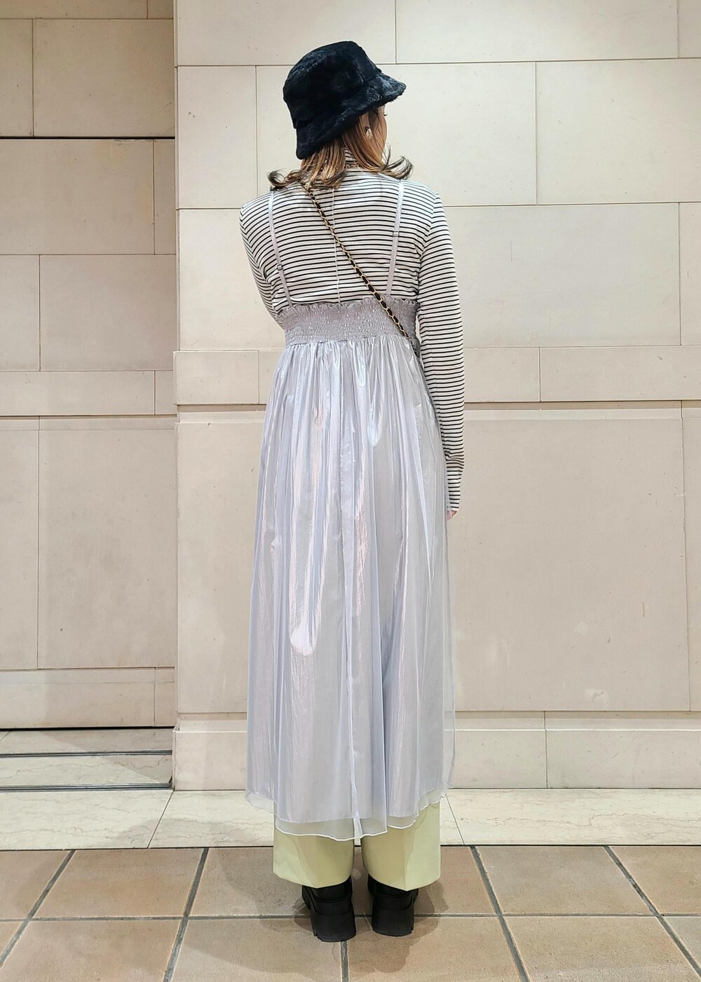 ブラック系のショルダーバッグ、ホワイト系のニット/セーター、グリーン系のスラックスを着用したレディースの冬コーディネートの4枚目の写真