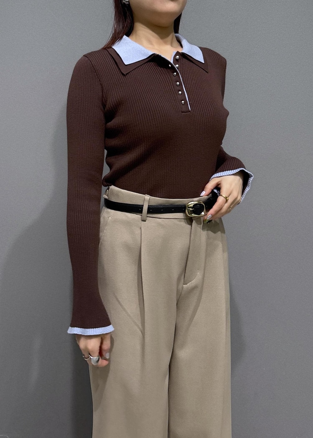 ブラウン系のショルダーバッグ、ベージュ系のスラックス、ブラック系のパンプスを着用したレディースの冬コーディネートの5枚目の写真