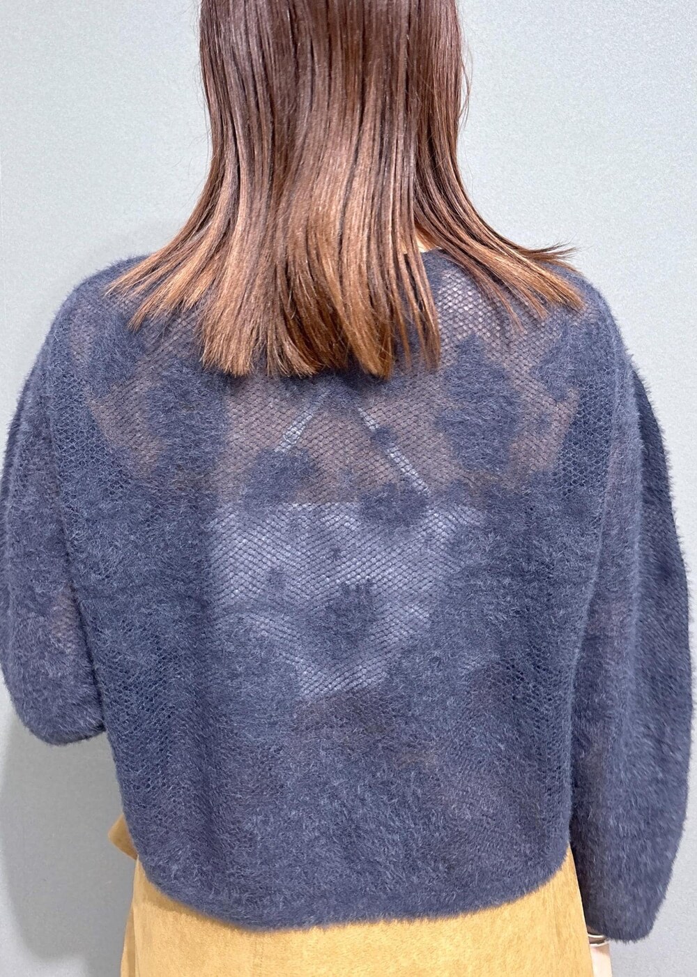 グレー系のニット/セーター、グレー系のスカート、ブラック系のショルダーバッグを着用したレディースの秋コーディネートの6枚目の写真