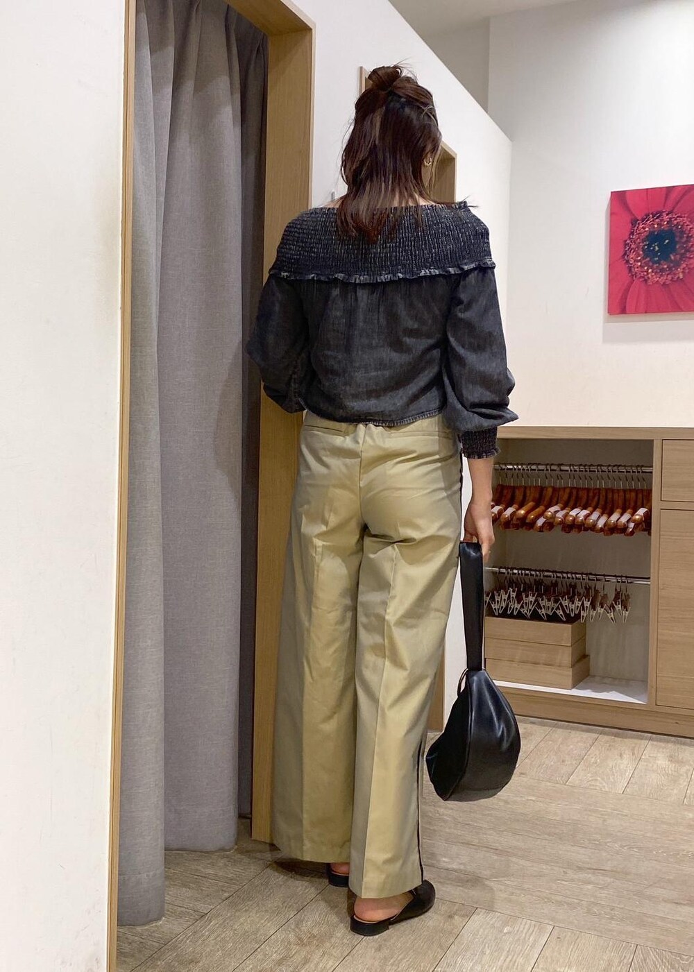 ベージュ系のスラックス、ブラック系のシャツ/ブラウス、ブラック系のハンドバッグを着用したレディースの春コーディネートの3枚目の写真