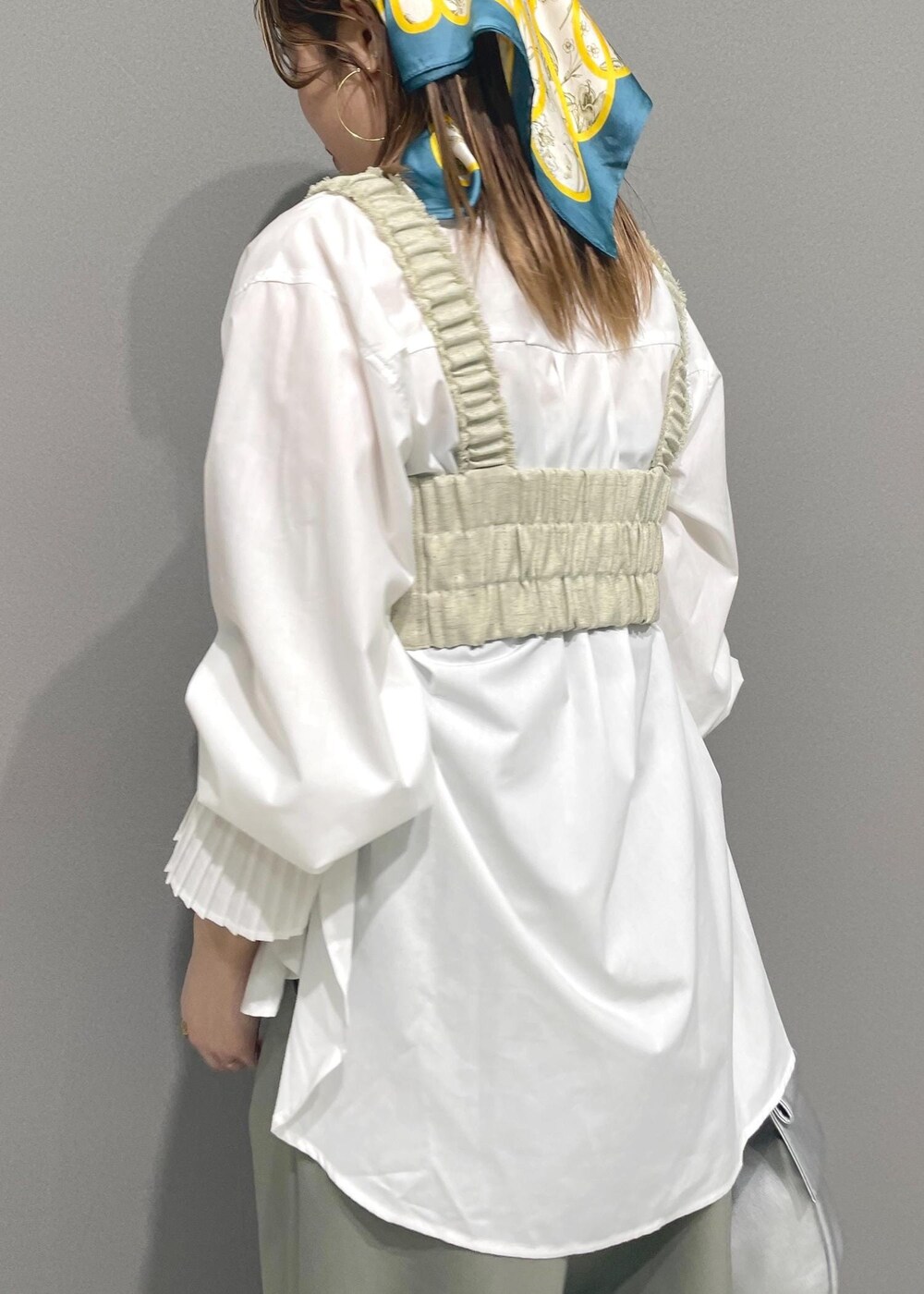 ホワイト系のシャツ/ブラウス、シルバー系のハンドバッグ、ホワイト系のベストを着用したレディースの冬コーディネートの5枚目の写真