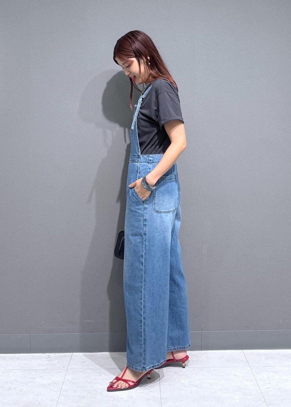 レッド系のサンダル、ブラック系のショルダーバッグ、グレー系のTシャツ/カットソーを着用したレディースの夏コーディネートの4枚目の写真