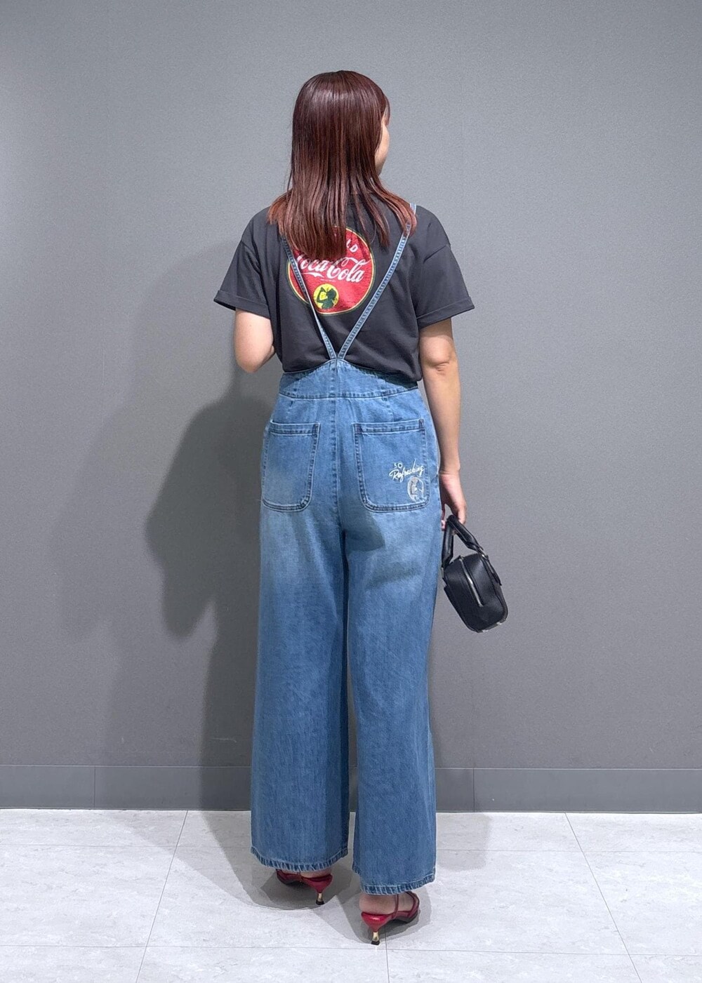 レッド系のサンダル、ブラック系のショルダーバッグ、グレー系のTシャツ/カットソーを着用したレディースの夏コーディネートの3枚目の写真