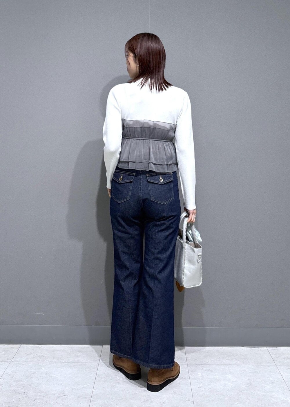 ベージュ系のローファー、シルバー系のトートバッグ、ホワイト系のニット/セーターを着用したレディースの冬コーディネートの4枚目の写真