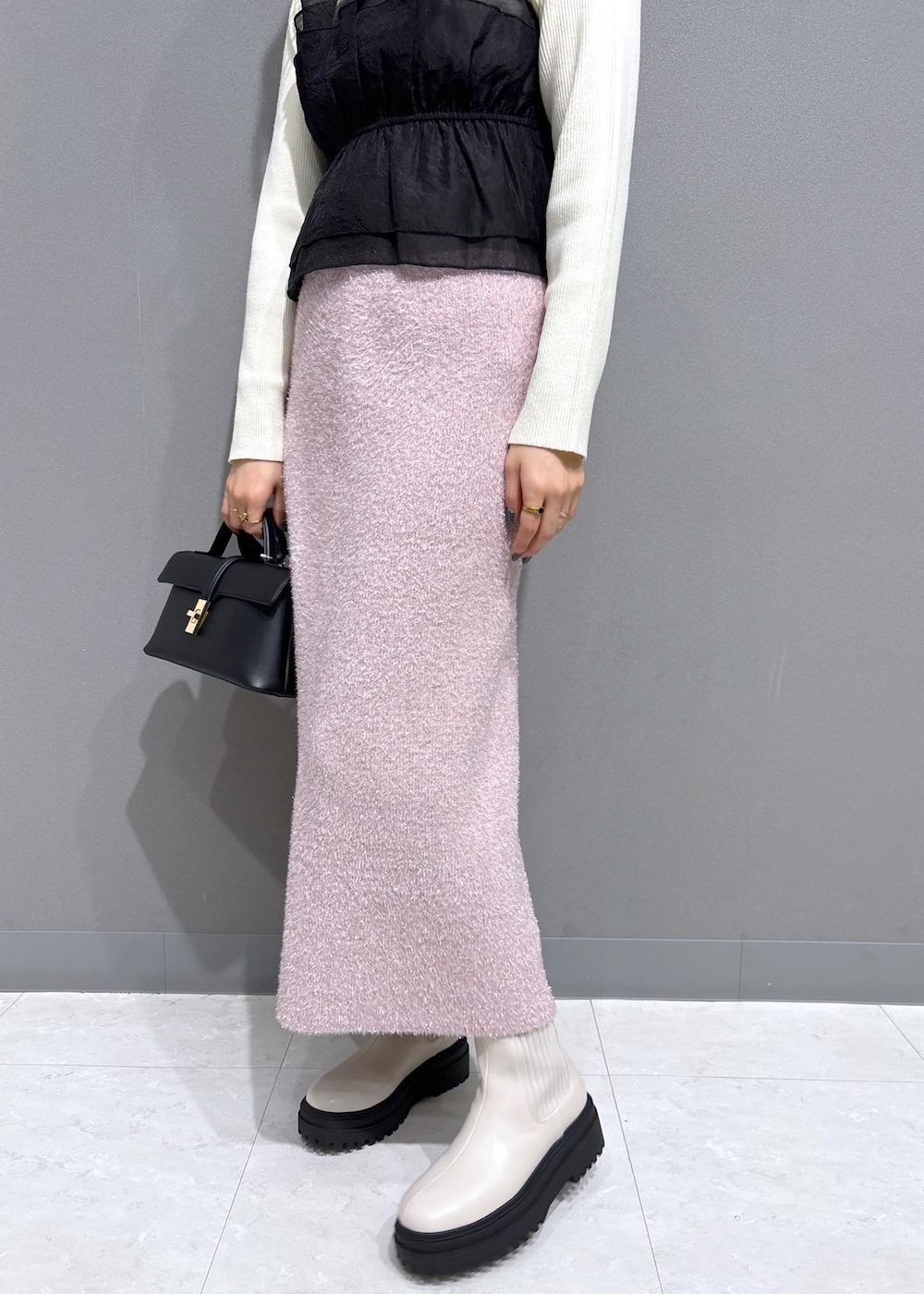 ホワイト系のブーツ、ピンク系のスカート、ホワイト系のニット/セーターを着用したレディースの冬コーディネートの6枚目の写真