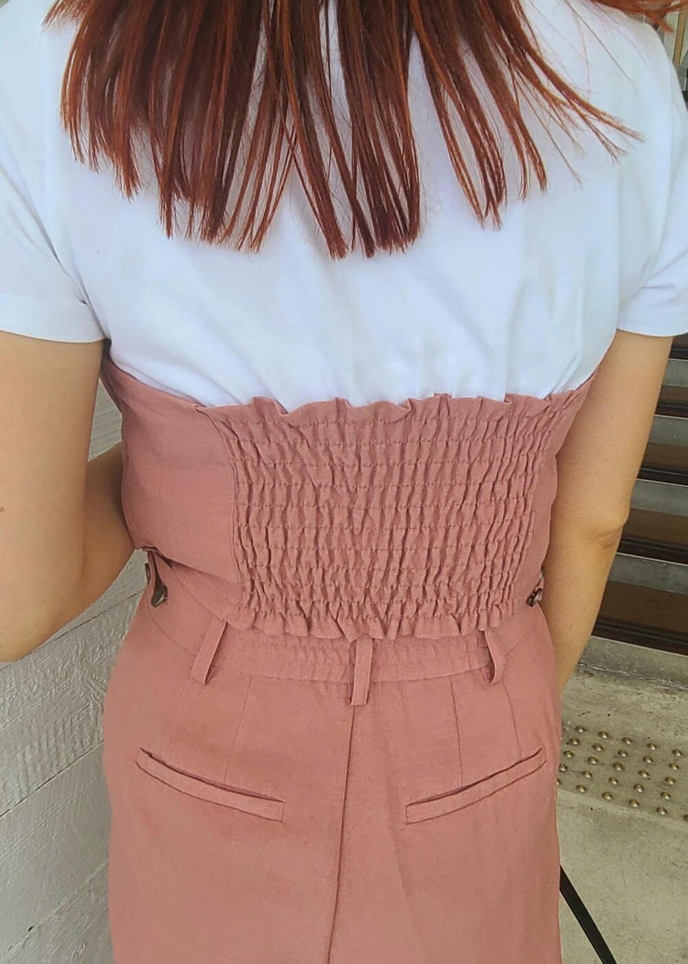 ブラック系のハンドバッグ、ピンク系のTシャツ/カットソー、ピンク系のスラックスを着用したレディースの夏コーディネートの6枚目の写真