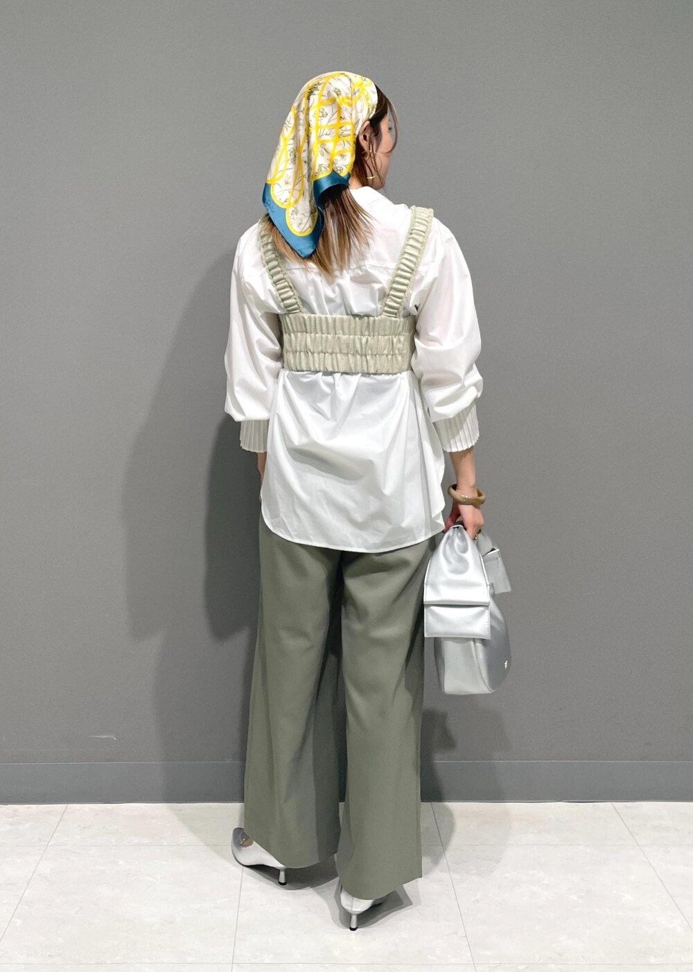 ホワイト系のシャツ/ブラウス、シルバー系のハンドバッグ、ホワイト系のベストを着用したレディースの冬コーディネートの4枚目の写真