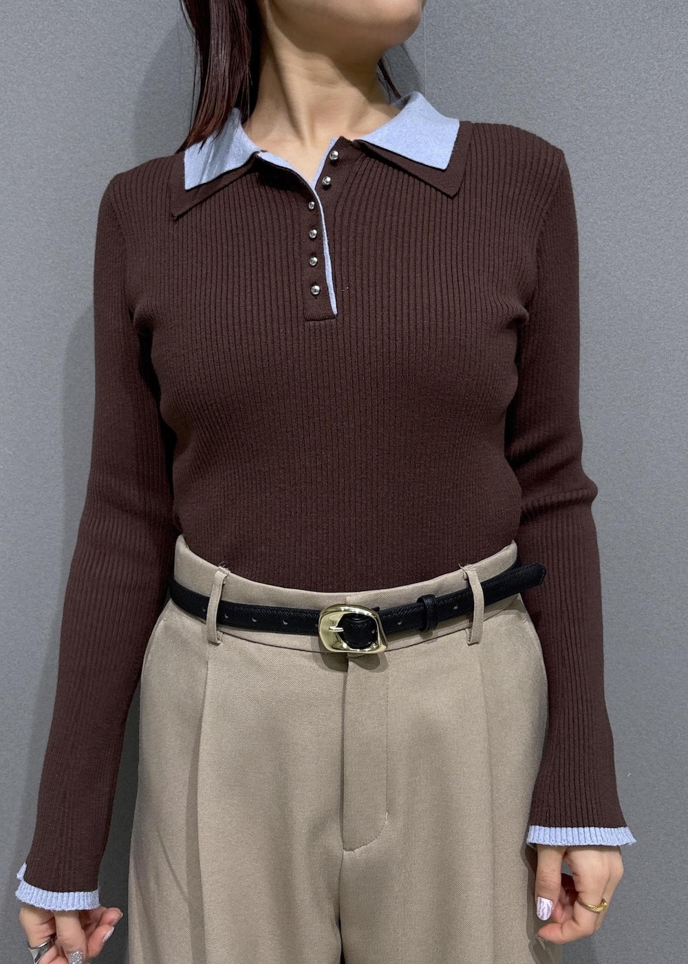 ブラウン系のショルダーバッグ、ベージュ系のスラックス、ブラック系のパンプスを着用したレディースの冬コーディネートの6枚目の写真