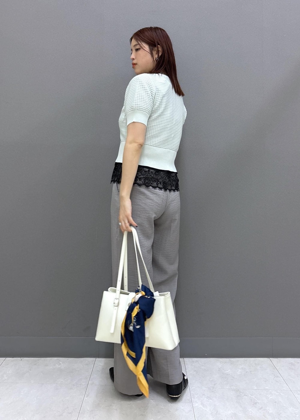 ブラック系のパンプス、グレー系のその他パンツ、ホワイト系のトートバッグを着用したレディースの春コーディネートの3枚目の写真