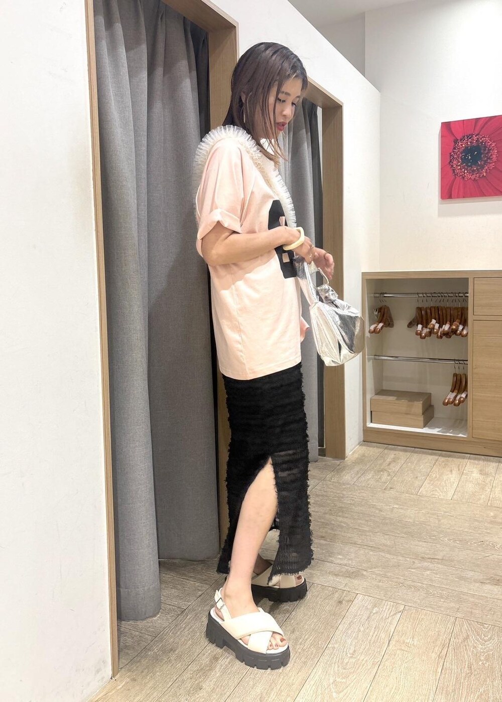 ホワイト系のサンダル、ブラック系のスカート、シルバー系のハンドバッグを着用したレディースの夏コーディネートの2枚目の写真