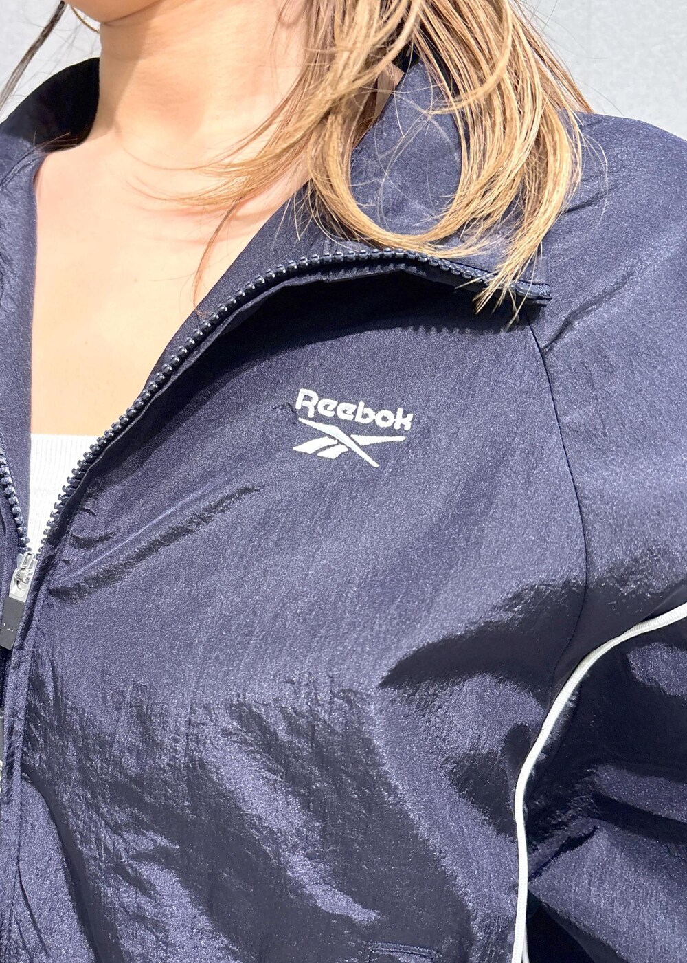 ブルー系のデニムスカート、ブルー系のブルゾン、ベージュ系のトレンチコートを着用したレディースの春コーディネートの5枚目の写真