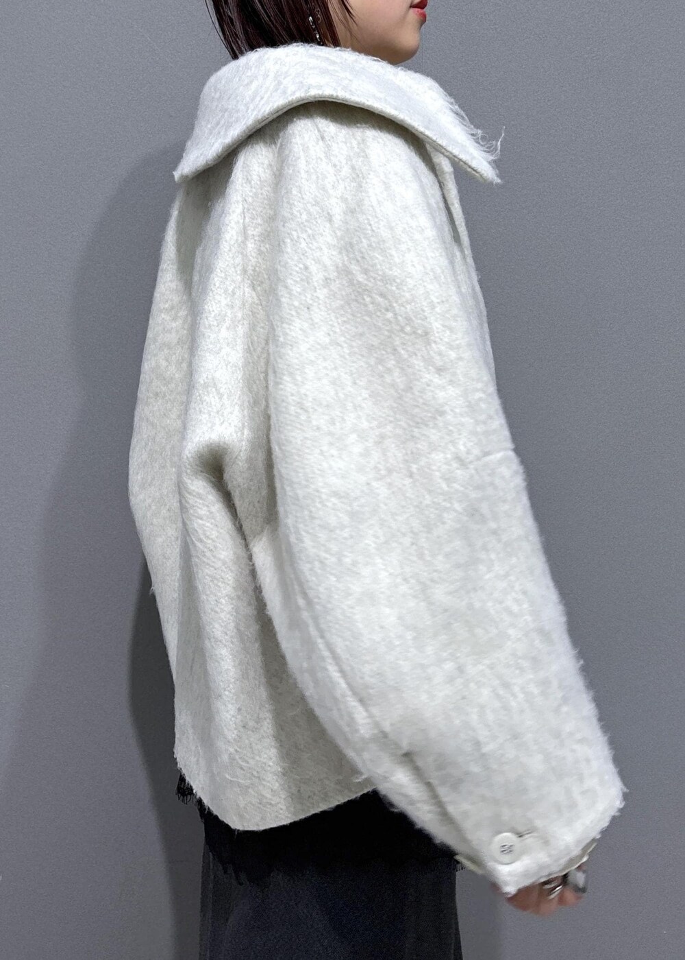 ブラウン系のブーツ、ホワイト系のブルゾン、ホワイト系のTシャツ/カットソーを着用したレディースの冬コーディネートの7枚目の写真