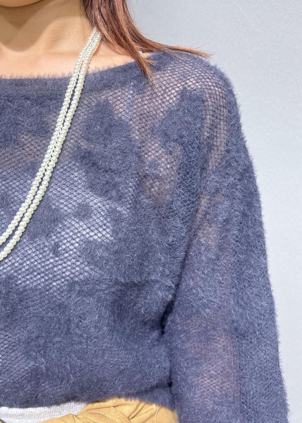 グレー系のニット/セーター、グレー系のスカート、ブラック系のショルダーバッグを着用したレディースの秋コーディネートの7枚目の写真