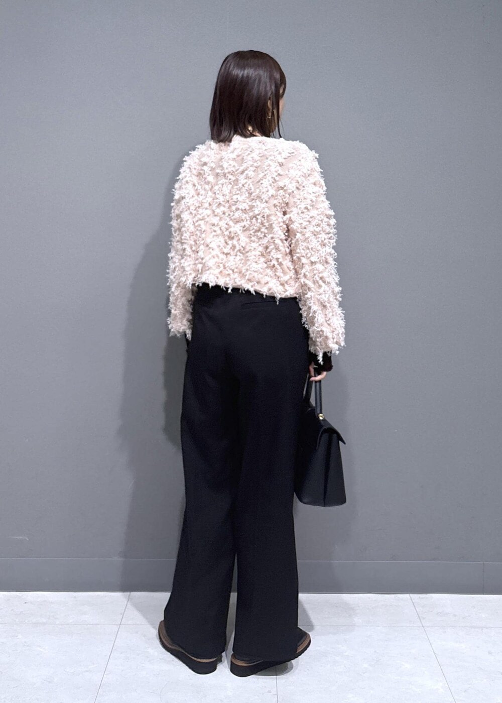 ブラック系のハンドバッグ、ブラック系のローファー、ブラウン系のTシャツ/カットソーを着用したレディースの秋コーディネートの3枚目の写真