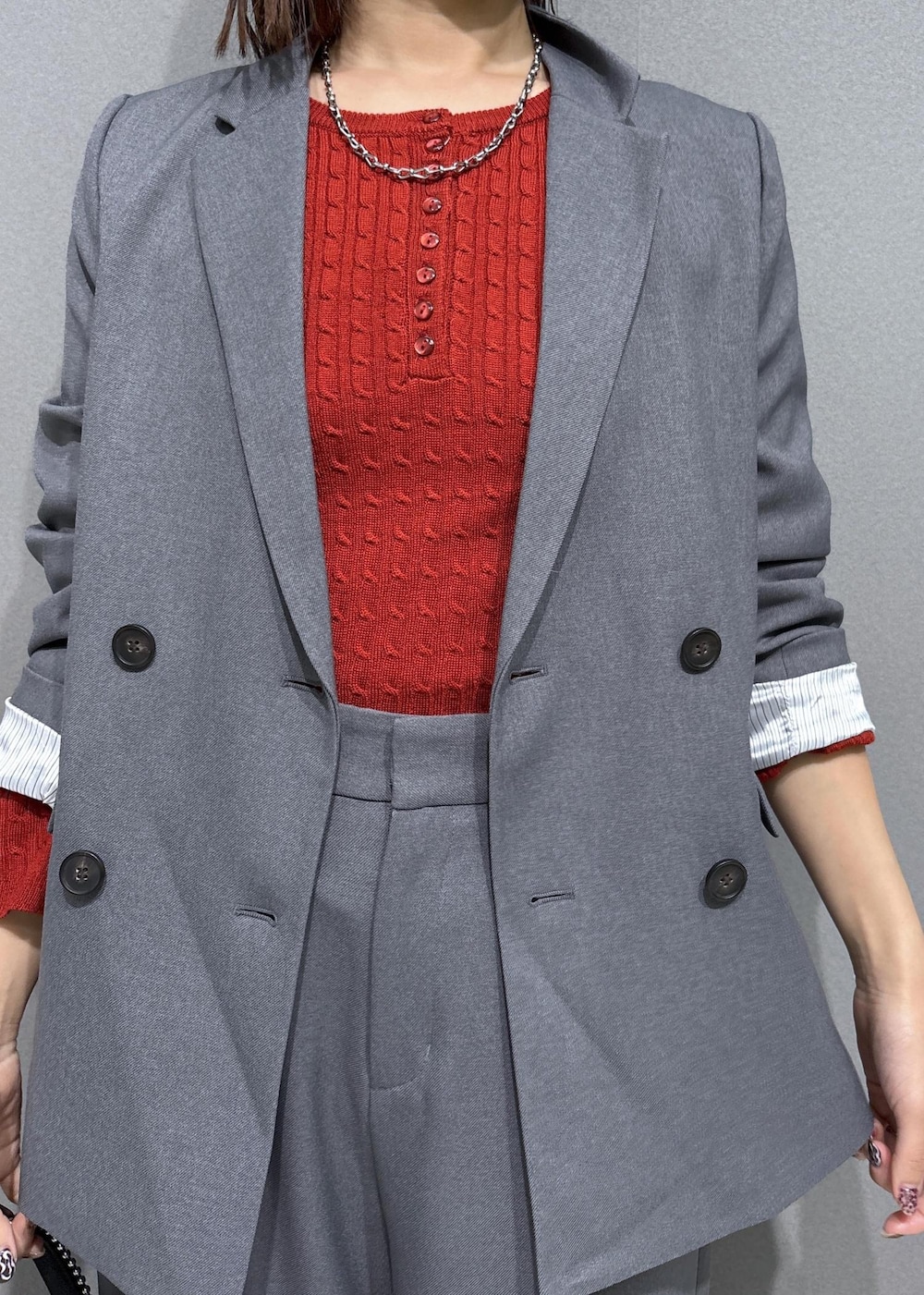 グレー系のスラックス、グレー系のテーラードジャケット、ブラック系のローファーを着用したレディースの秋コーディネートの4枚目の写真