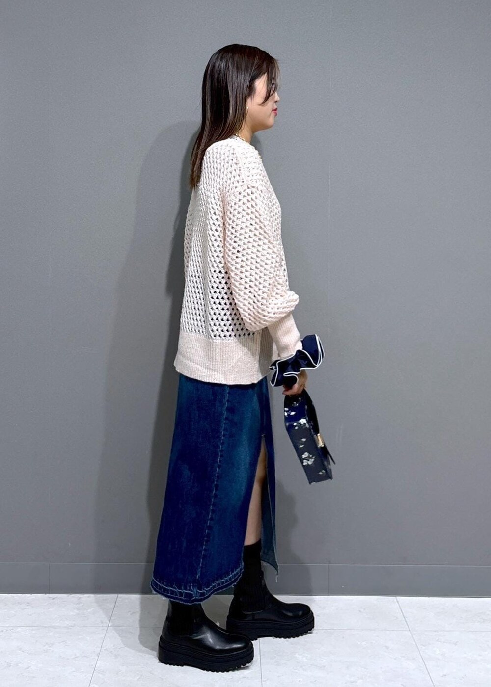 ブラック系のブーツ、ホワイト系のTシャツ/カットソー、ピンク系のニット/セーターを着用したレディースの冬コーディネートの2枚目の写真