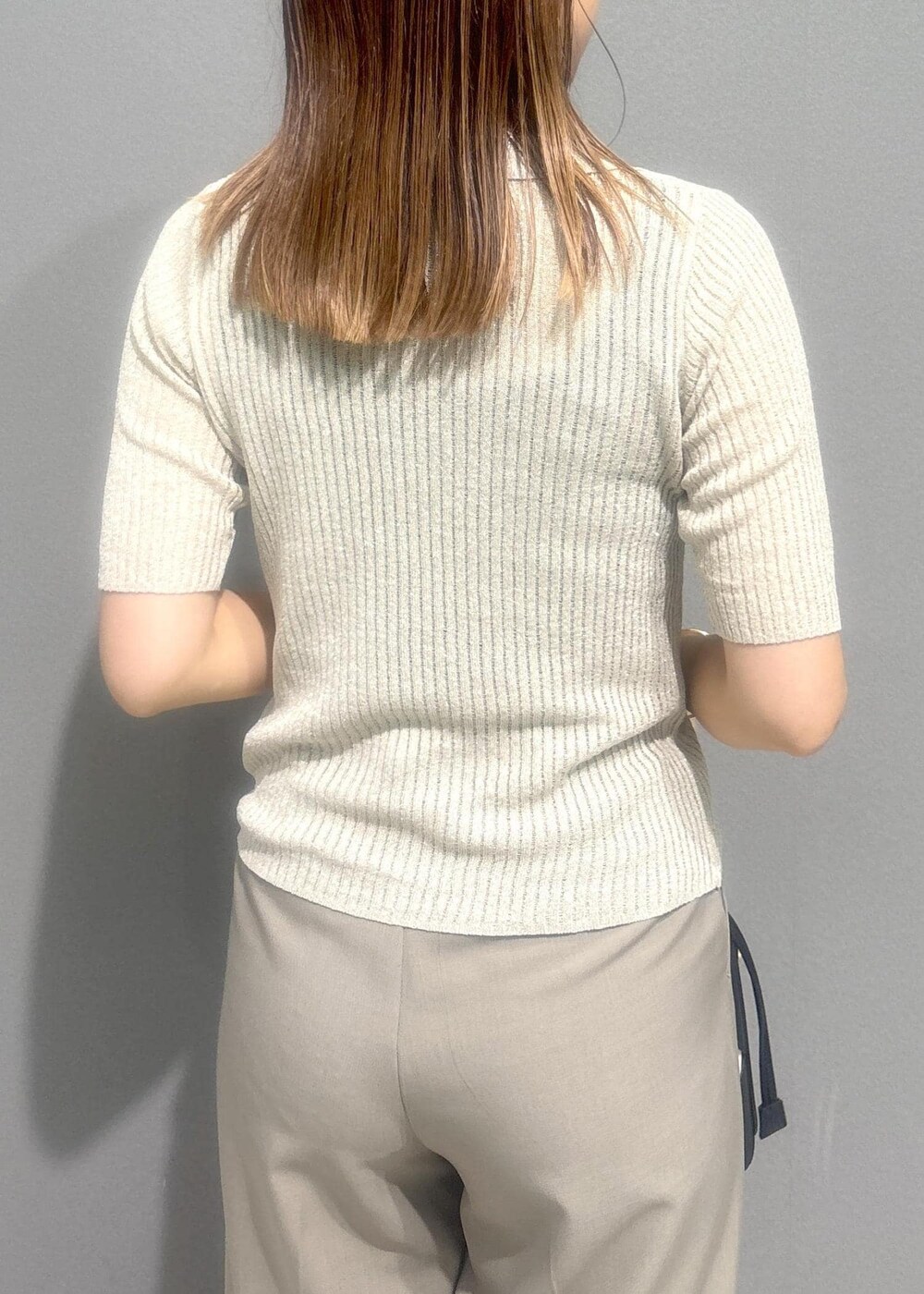 ブラック系のバレエシューズ、ベージュ系のスラックス、ホワイト系のカーディガン/ボレロを着用したレディースの夏コーディネートの6枚目の写真