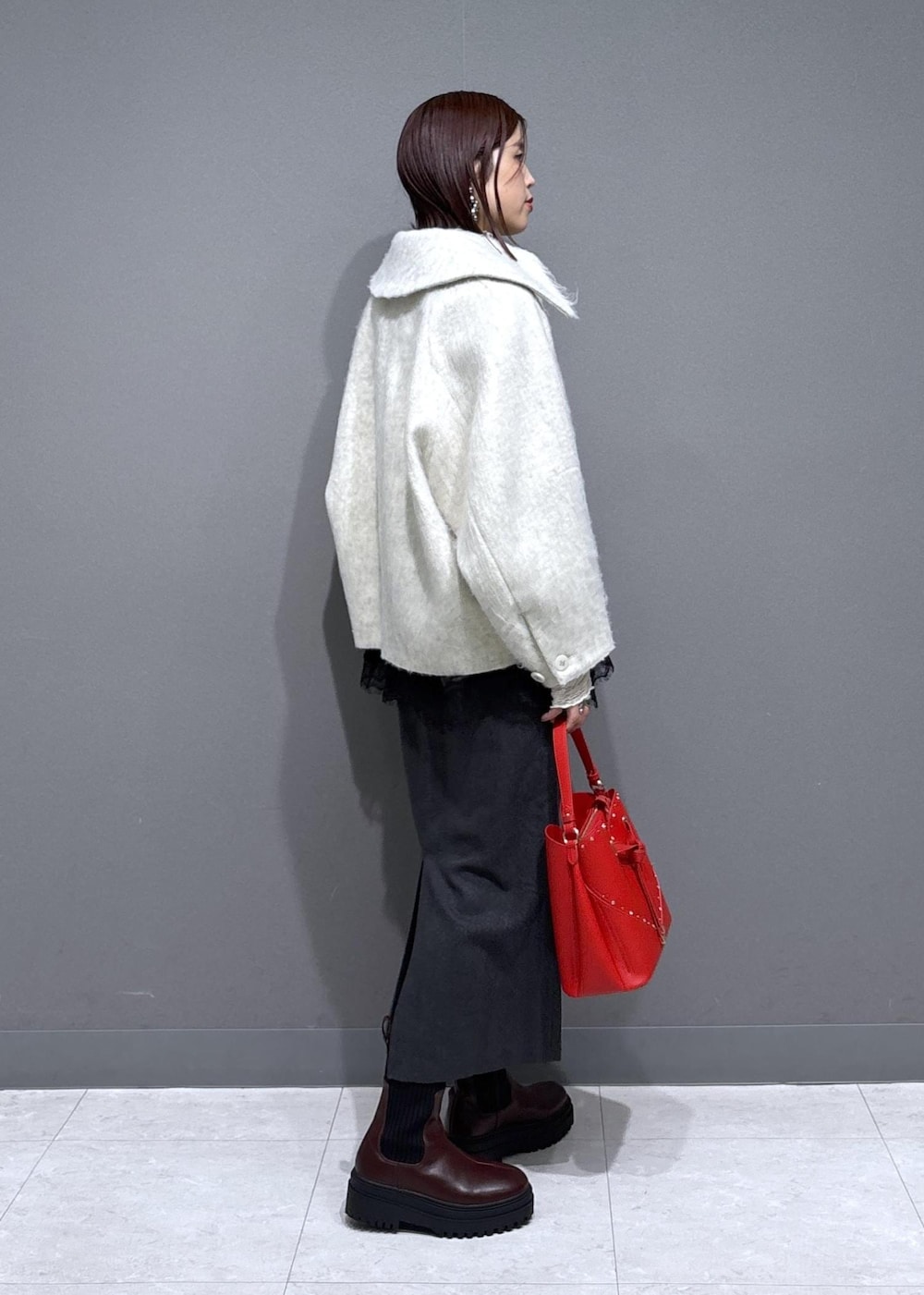 ブラウン系のブーツ、ホワイト系のブルゾン、ホワイト系のTシャツ/カットソーを着用したレディースの冬コーディネートの2枚目の写真