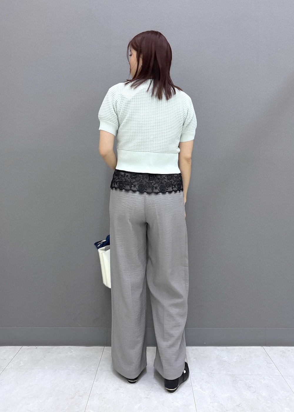 ブラック系のパンプス、グレー系のその他パンツ、ホワイト系のトートバッグを着用したレディースの春コーディネートの4枚目の写真