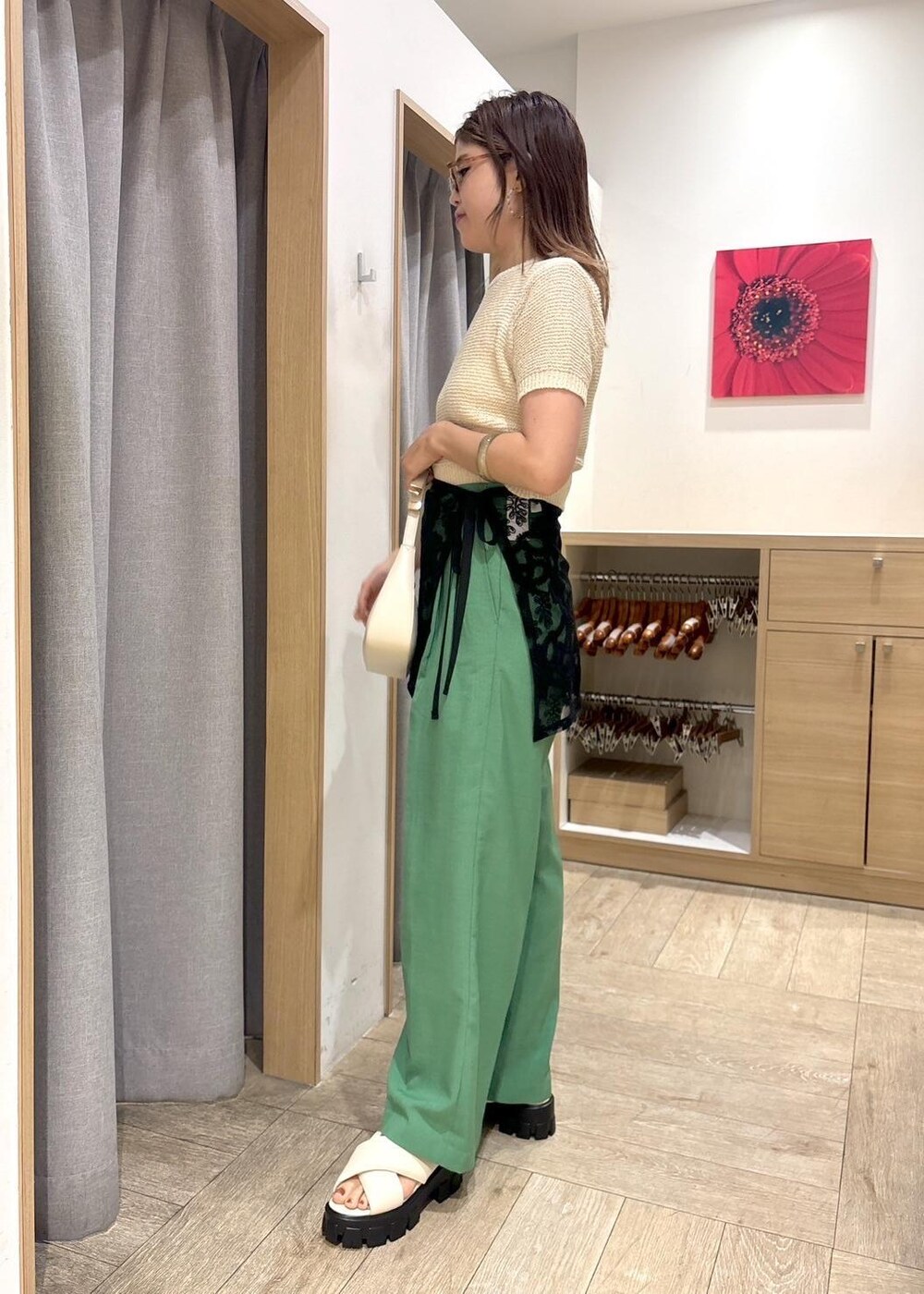 ホワイト系のハンドバッグ、ホワイト系のニット/セーター、ホワイト系のサンダルを着用したレディースの春コーディネートの2枚目の写真