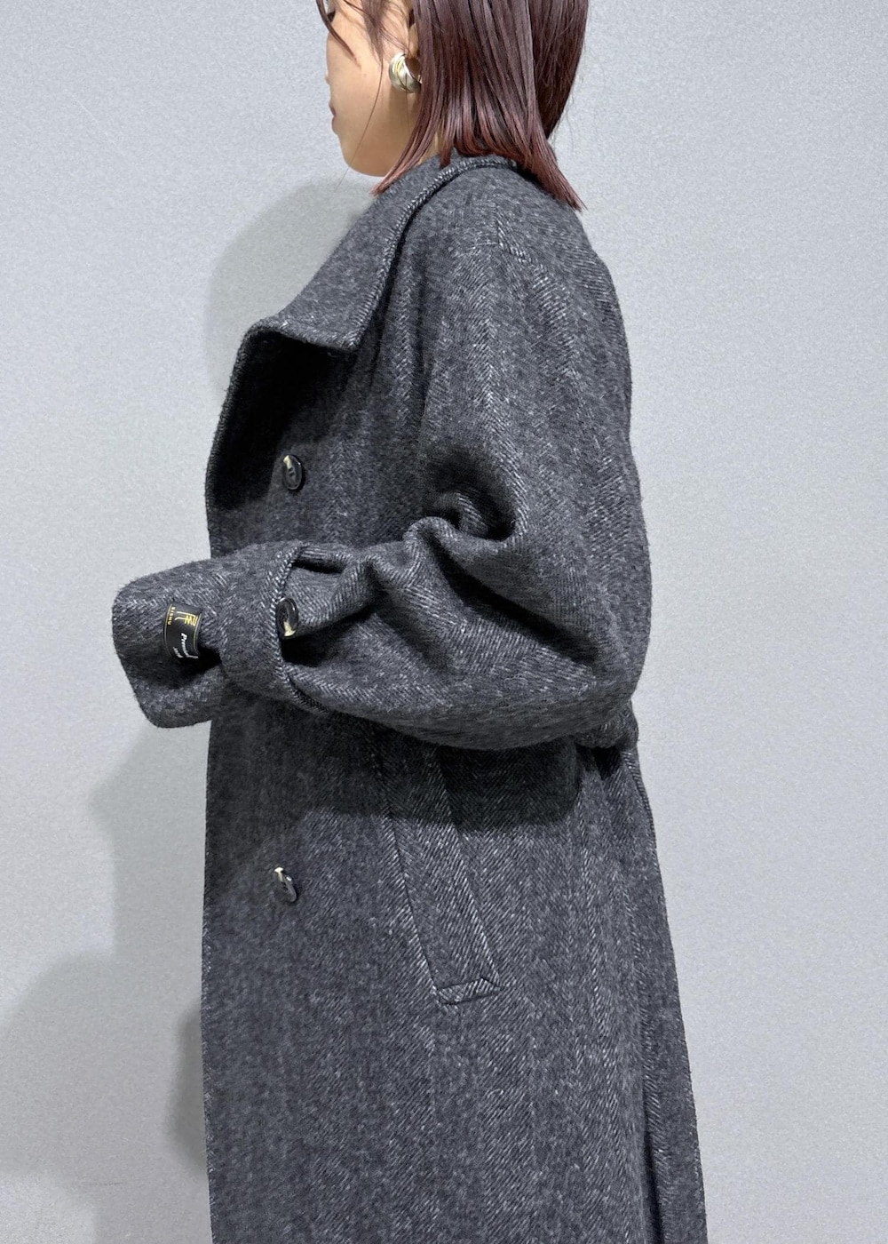 ブラウン系のスラックス、ブラウン系のブーツ、グレー系のその他アウターを着用したレディースの冬コーディネートの8枚目の写真