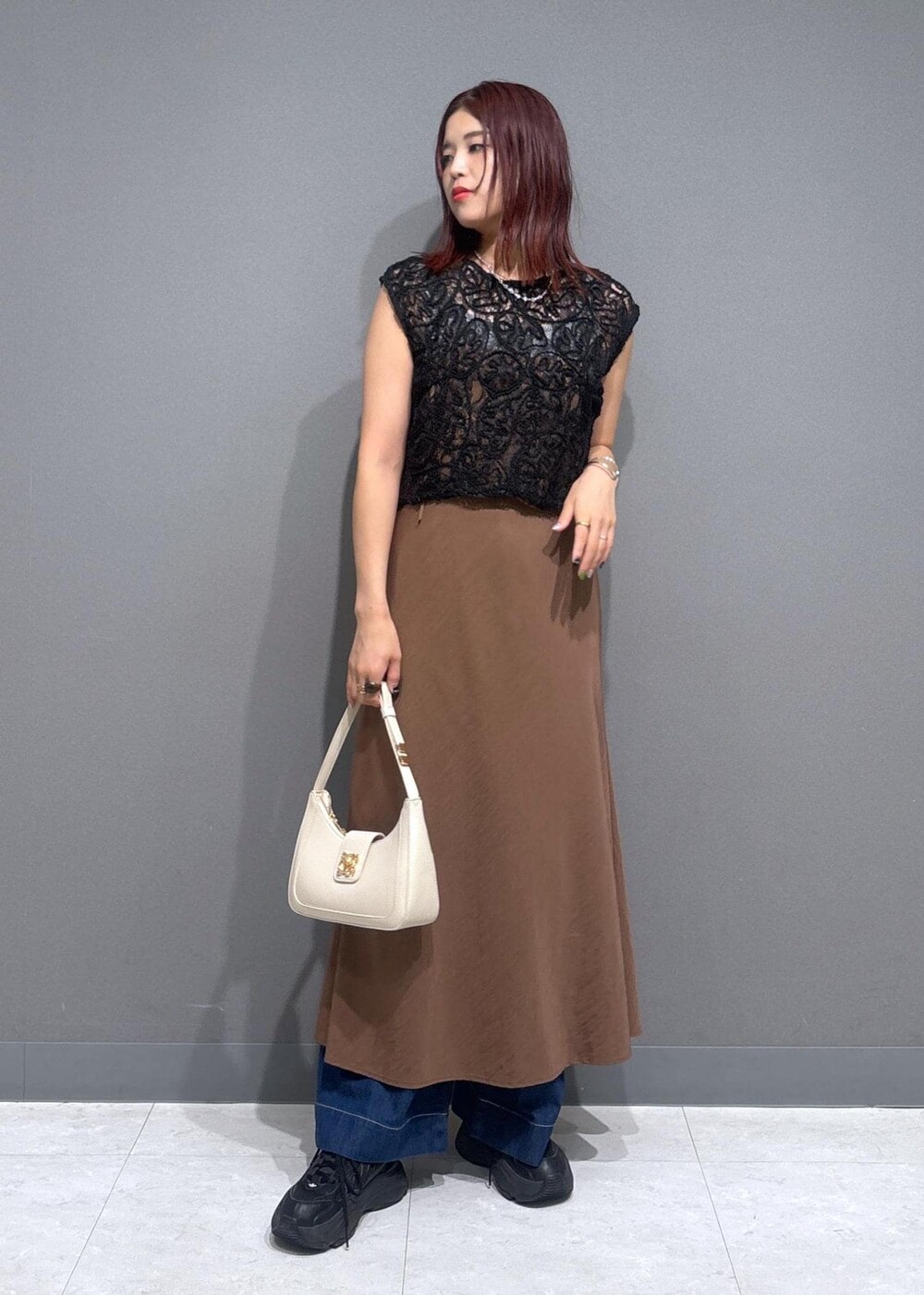 グレー系のタンクトップ、ブルー系のデニムパンツ、ホワイト系のショルダーバッグを着用したレディースの夏コーディネートの2枚目の写真