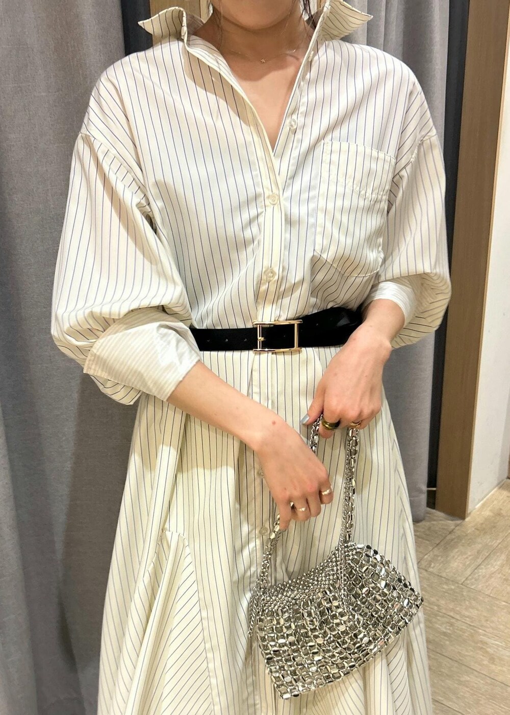 イエロー系のシャツワンピース、イエロー系のスラックス、シルバー系のショルダーバッグを着用したレディースの春コーディネートの3枚目の写真