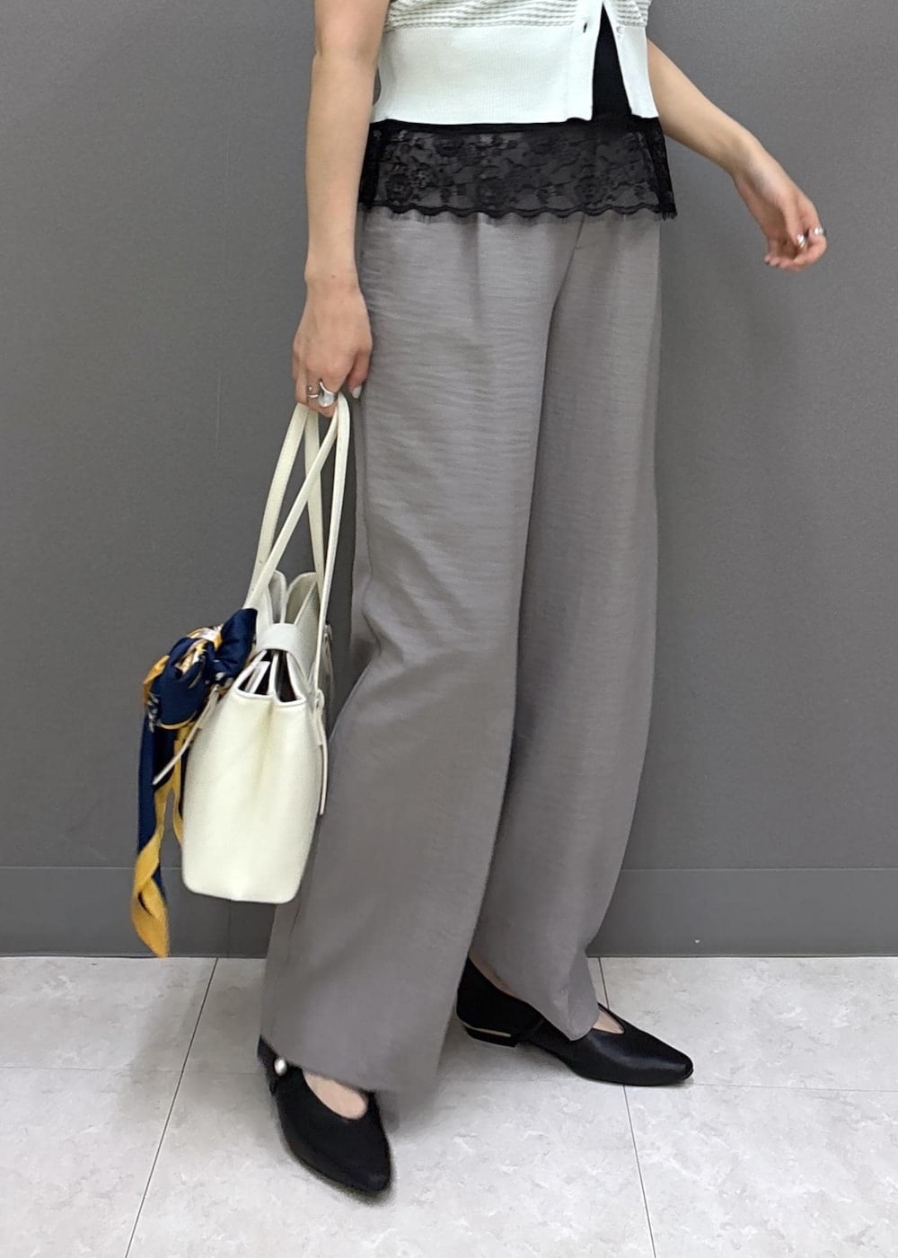 ブラック系のパンプス、グレー系のその他パンツ、ホワイト系のトートバッグを着用したレディースの春コーディネートの8枚目の写真