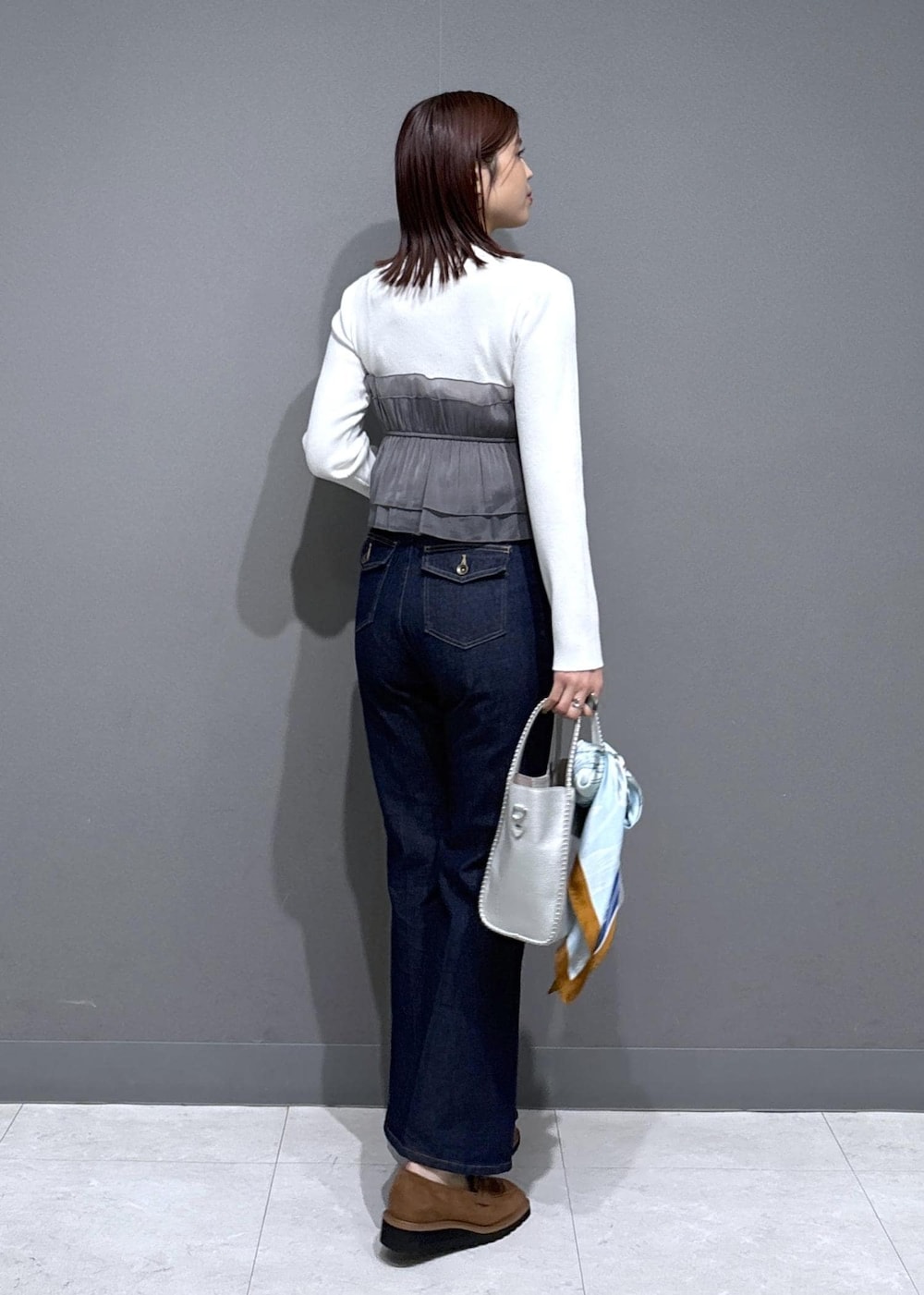 ベージュ系のローファー、シルバー系のトートバッグ、ホワイト系のニット/セーターを着用したレディースの冬コーディネートの3枚目の写真