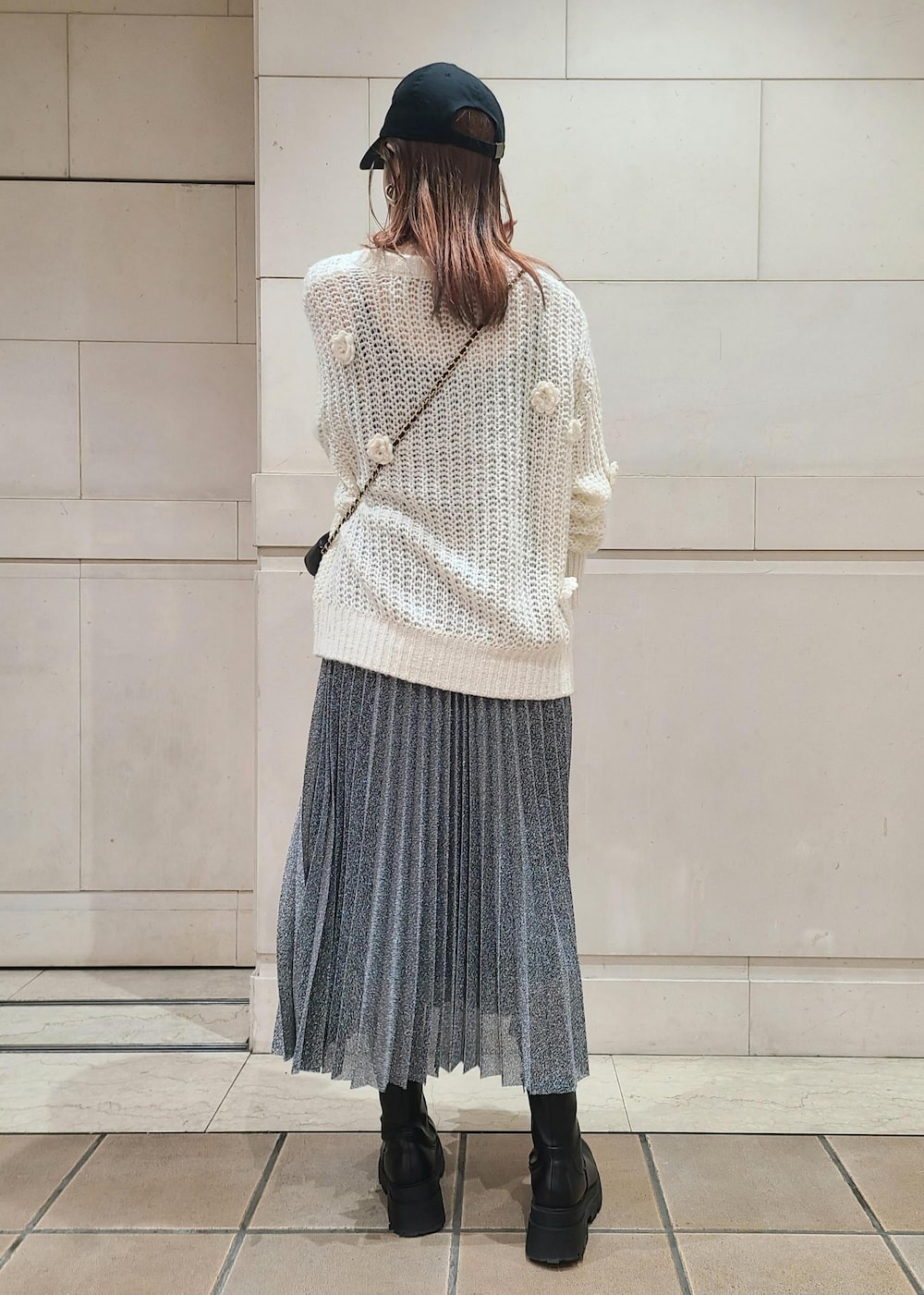 ブラック系のスカート、ホワイト系のニット/セーター、ブラック系のショルダーバッグを着用したレディースの冬コーディネートの2枚目の写真