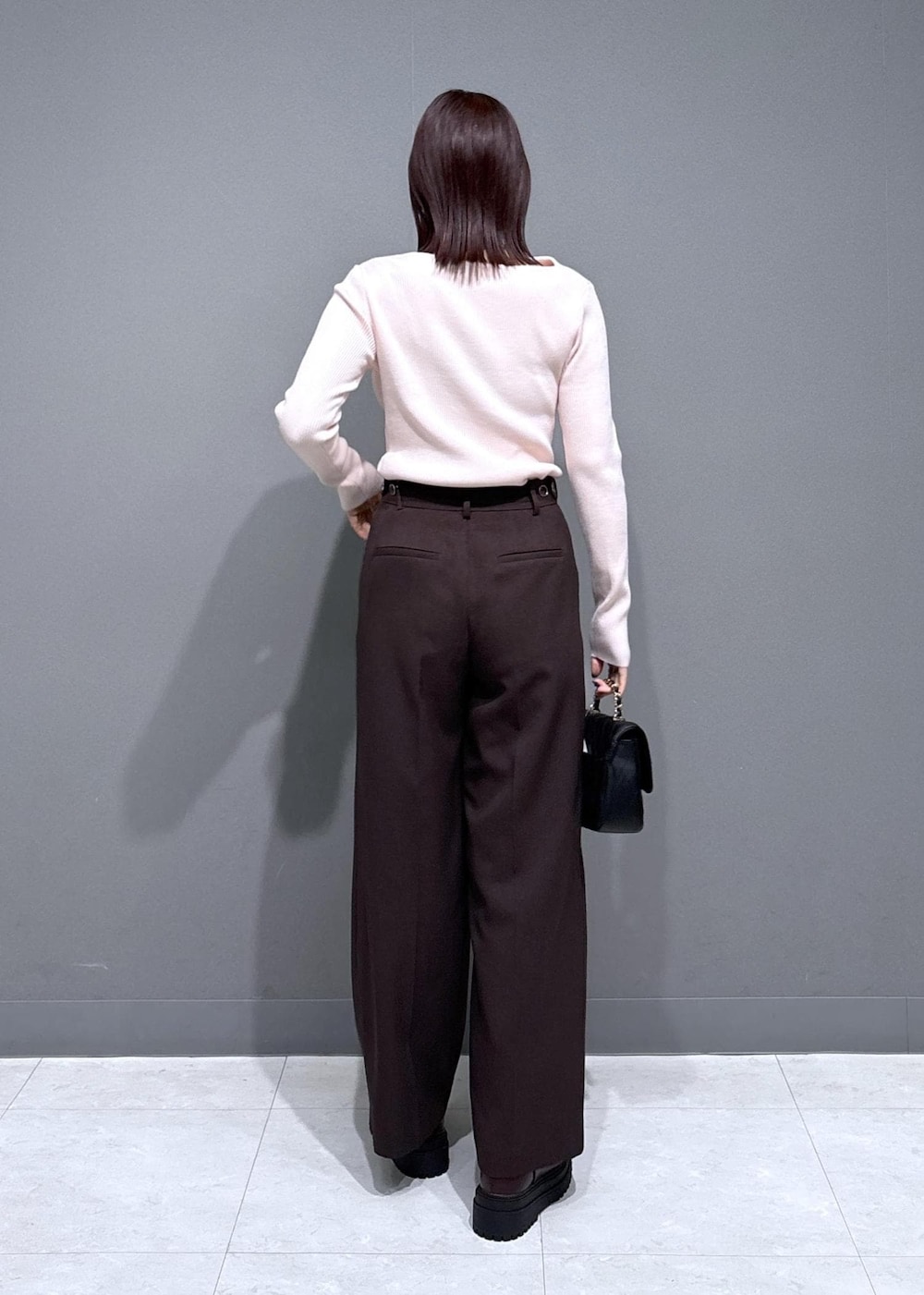 ブラウン系のスラックス、ブラウン系のブーツ、グレー系のその他アウターを着用したレディースの冬コーディネートの6枚目の写真