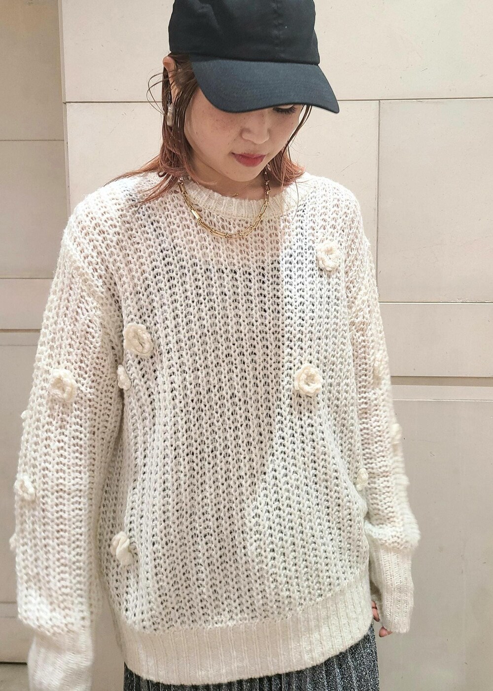 ブラック系のスカート、ホワイト系のニット/セーター、ブラック系のショルダーバッグを着用したレディースの冬コーディネートの3枚目の写真