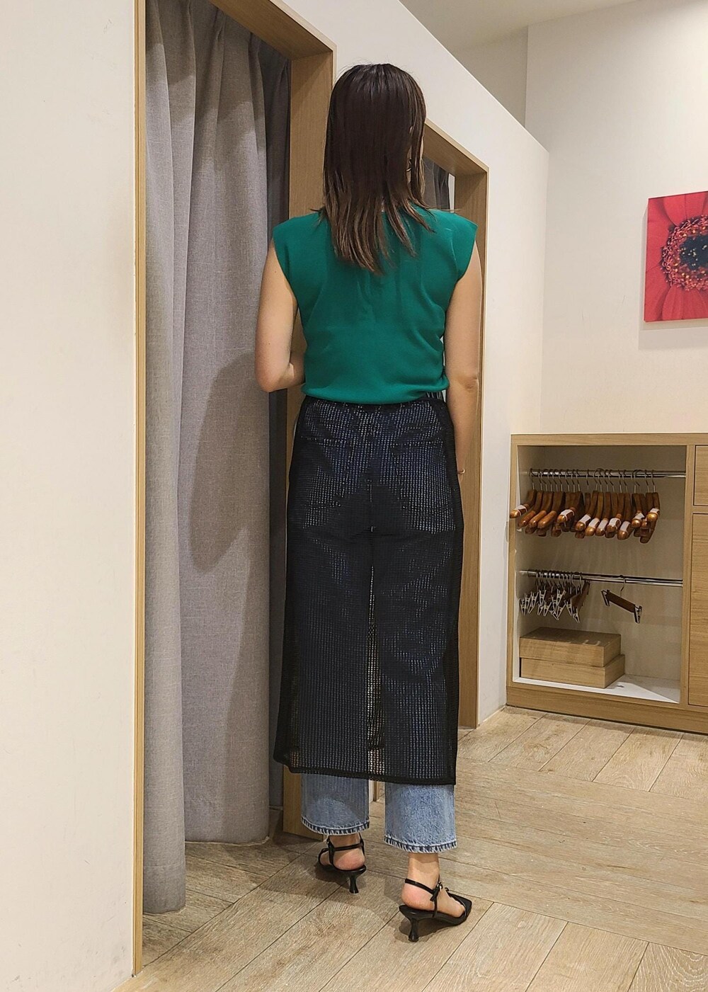 シルバー系のショルダーバッグ、ブルー系のデニムパンツ、グリーン系のニット/セーターを着用したレディースの春コーディネートの2枚目の写真