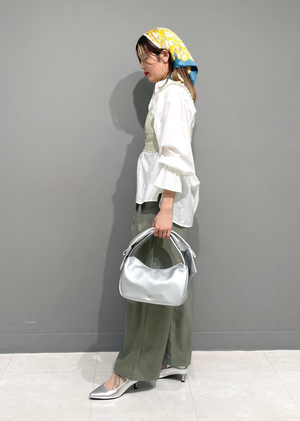 ホワイト系のシャツ/ブラウス、シルバー系のハンドバッグ、ホワイト系のベストを着用したレディースの冬コーディネートの2枚目の写真