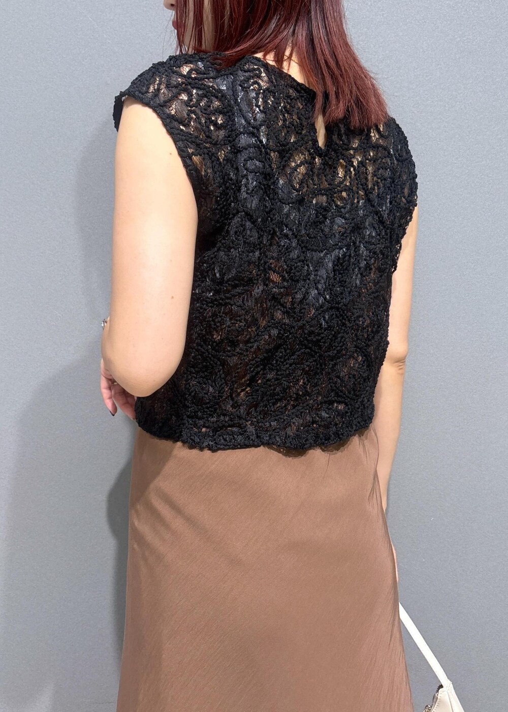 グレー系のタンクトップ、ブルー系のデニムパンツ、ホワイト系のショルダーバッグを着用したレディースの夏コーディネートの6枚目の写真