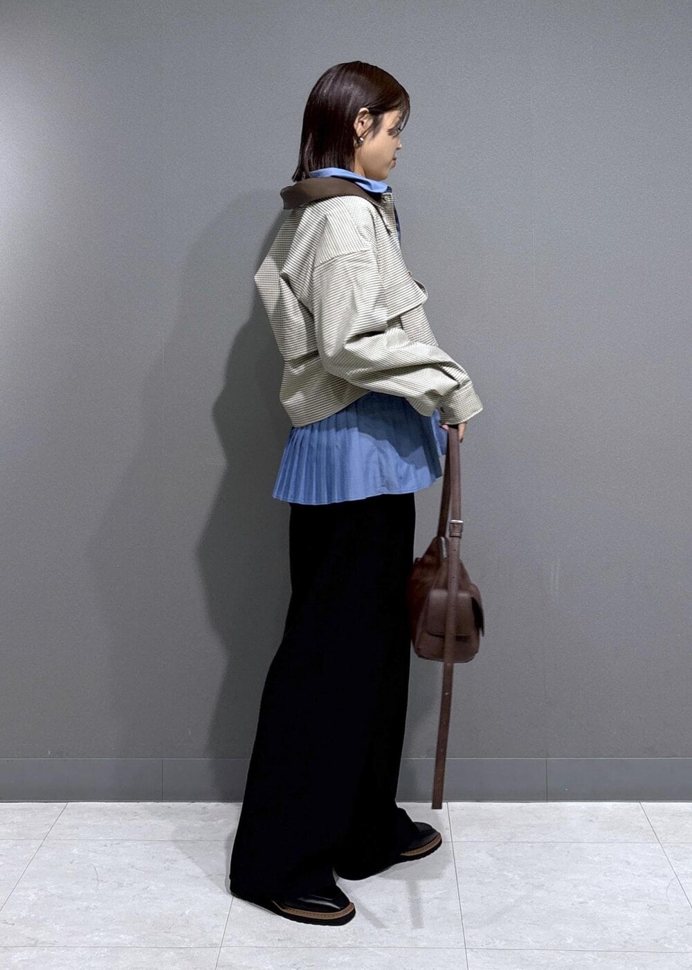 ブラック系のローファー、ブルー系のシャツ/ブラウス、ベージュ系のカバーオールを着用したレディースの秋コーディネートの3枚目の写真