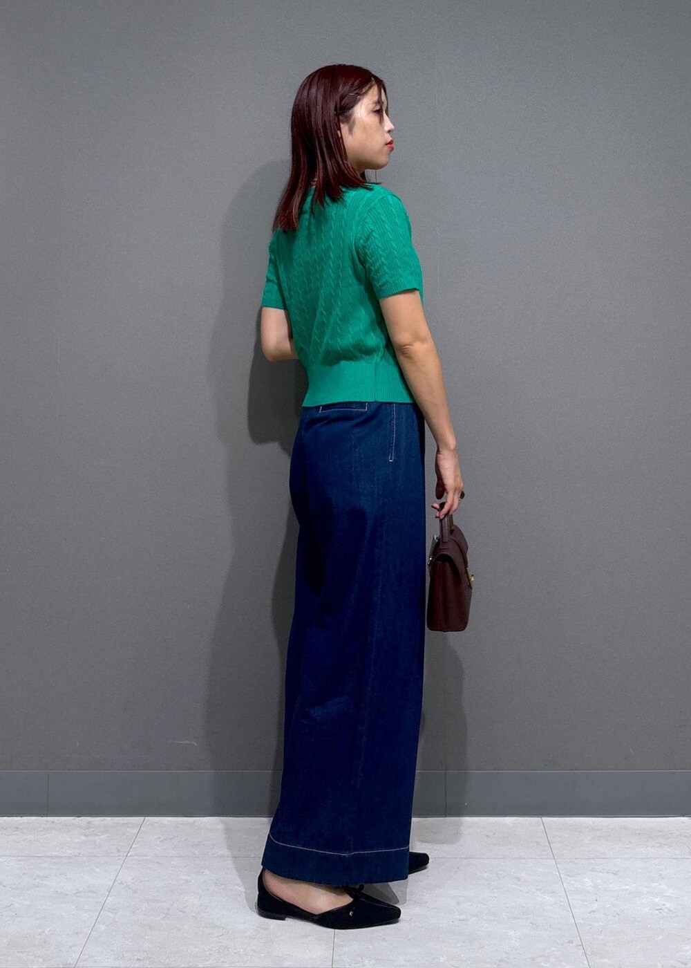 ブラウン系のショルダーバッグ、グレー系のタンクトップ、ブルー系のデニムパンツを着用したレディースの夏コーディネートの3枚目の写真