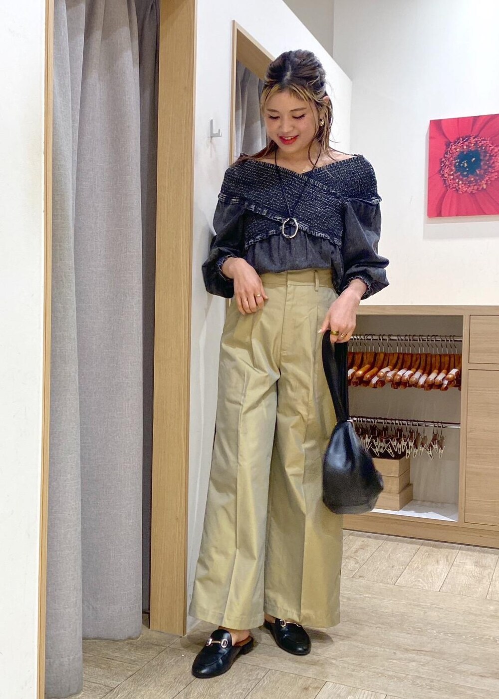 ベージュ系のスラックス、ブラック系のシャツ/ブラウス、ブラック系のハンドバッグを着用したレディースの春コーディネートの2枚目の写真