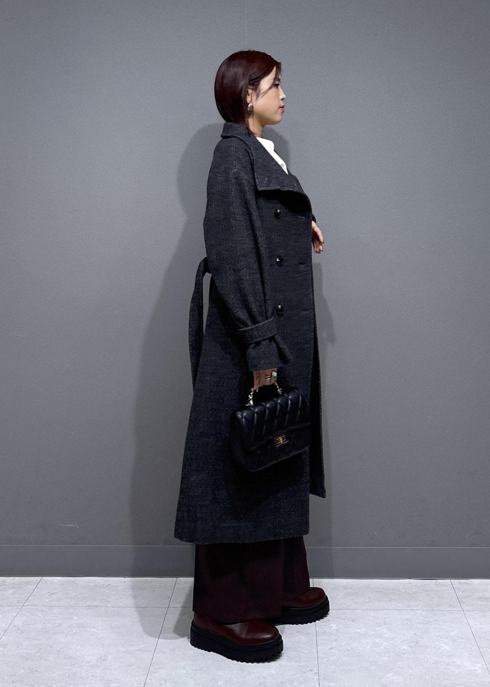 ブラウン系のスラックス、ブラウン系のブーツ、グレー系のその他アウターを着用したレディースの冬コーディネートの2枚目の写真