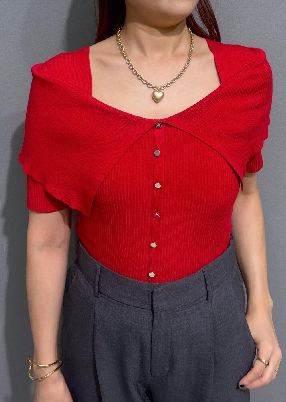 グレー系のスラックス、ブラウン系のボストンバッグ、レッド系のニット/セーターを着用したレディースの夏コーディネートの4枚目の写真