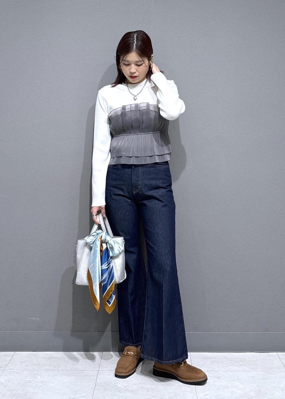 ベージュ系のローファー、シルバー系のトートバッグ、ホワイト系のニット/セーターを着用したレディースの冬コーディネートの2枚目の写真