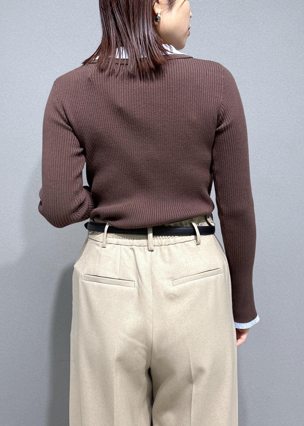 ブラウン系のショルダーバッグ、ベージュ系のスラックス、ブラック系のパンプスを着用したレディースの冬コーディネートの8枚目の写真