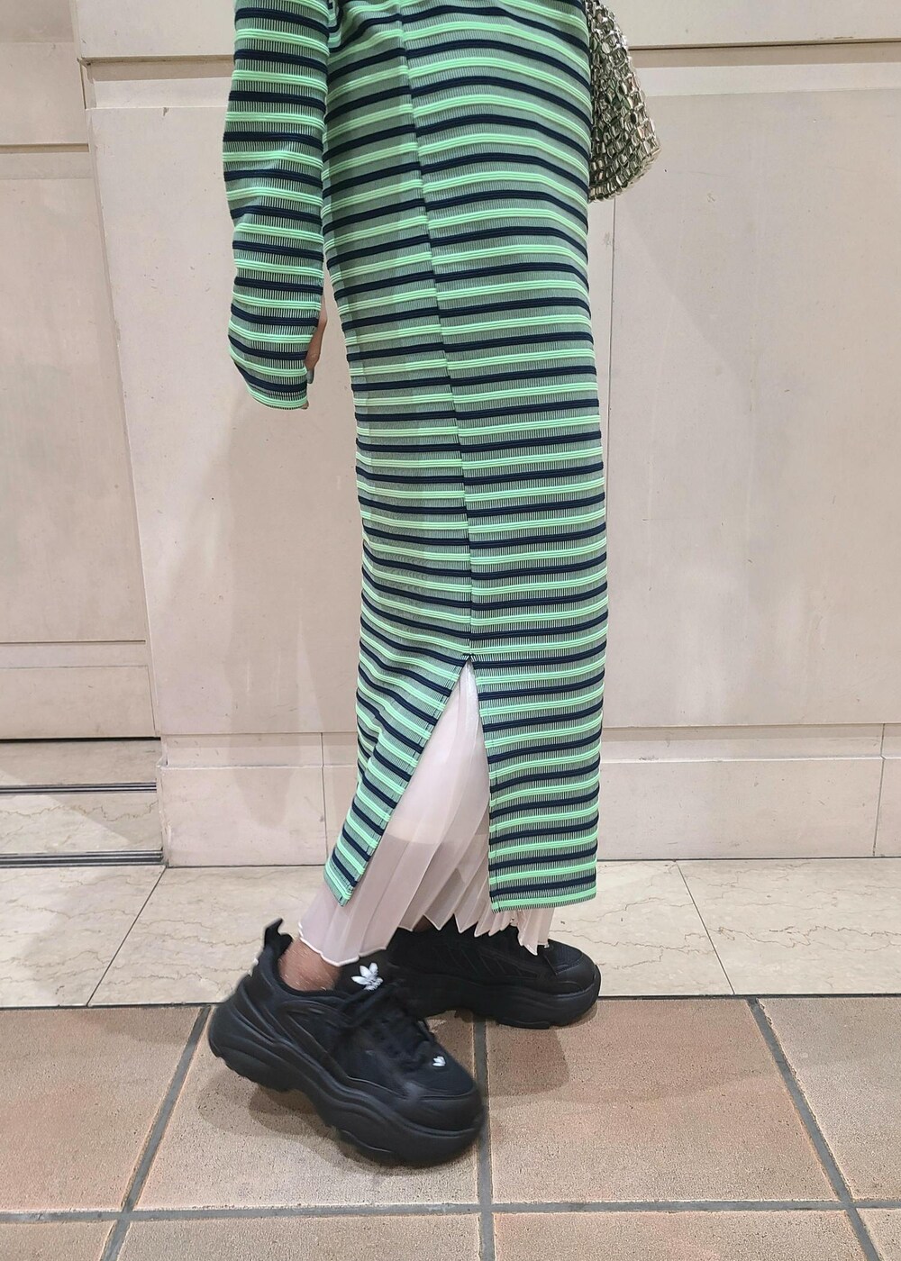 ホワイト系のデニムジャケット、シルバー系のショルダーバッグ、ホワイト系のスカートを着用したレディースの冬コーディネートの4枚目の写真