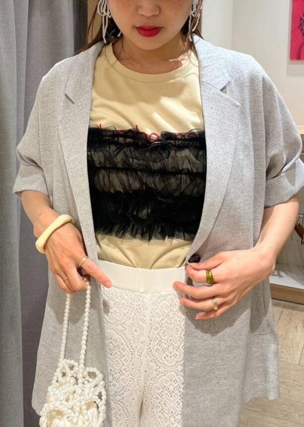 ブラック系のサンダル、グレー系のテーラードジャケット、ホワイト系のその他パンツを着用したレディースの春コーディネートの3枚目の写真