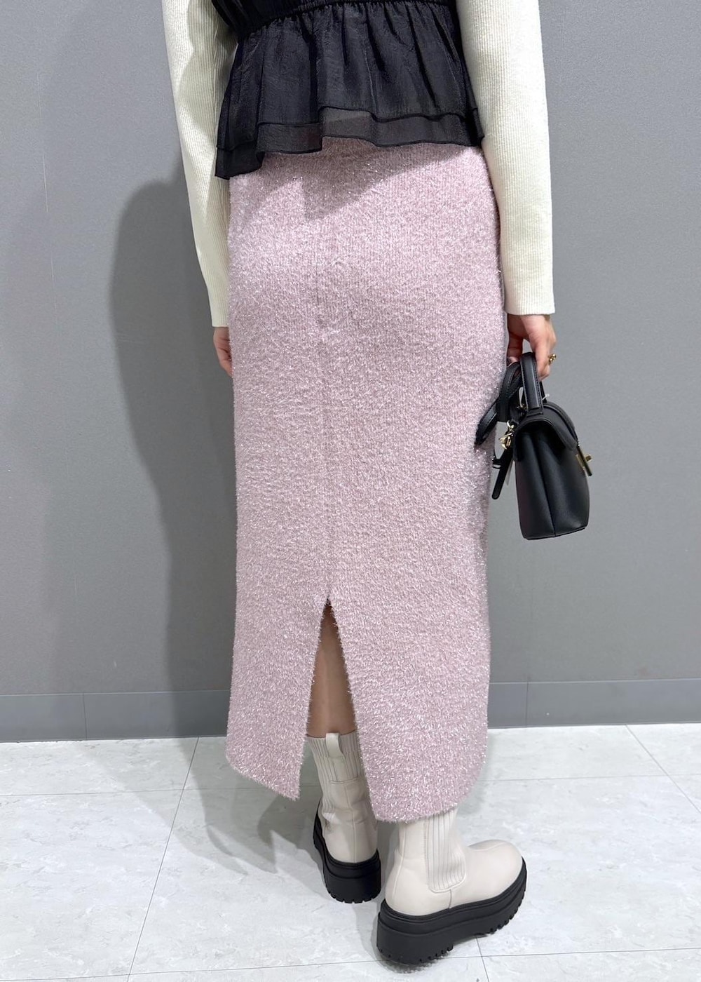 ホワイト系のブーツ、ピンク系のスカート、ホワイト系のニット/セーターを着用したレディースの冬コーディネートの8枚目の写真