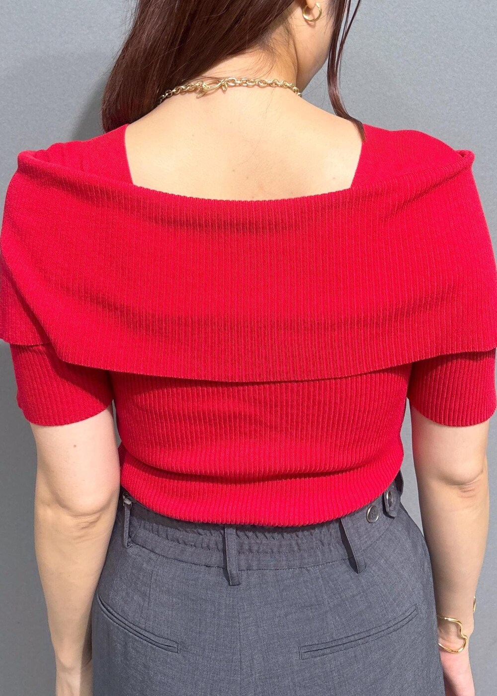 グレー系のスラックス、ブラウン系のボストンバッグ、レッド系のニット/セーターを着用したレディースの夏コーディネートの5枚目の写真