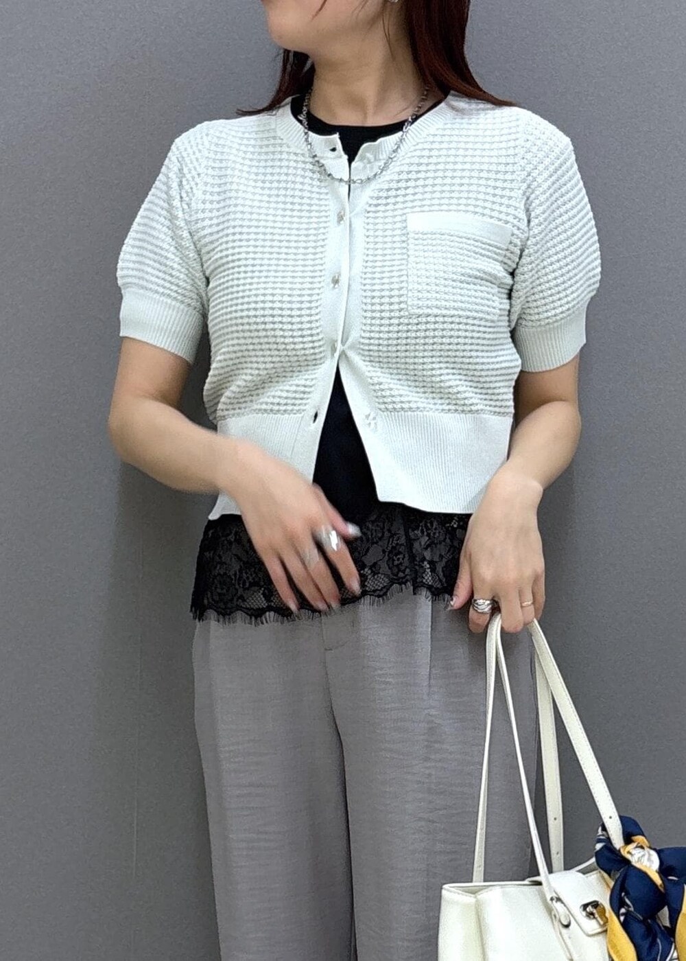 ブラック系のパンプス、グレー系のその他パンツ、ホワイト系のトートバッグを着用したレディースの春コーディネートの5枚目の写真