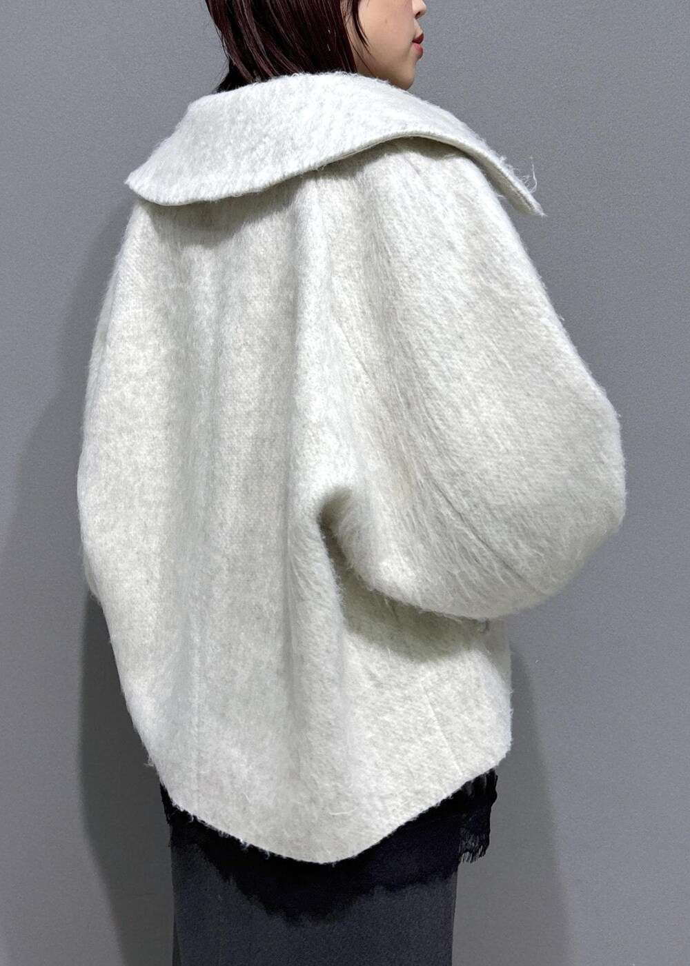 ブラウン系のブーツ、ホワイト系のブルゾン、ホワイト系のTシャツ/カットソーを着用したレディースの冬コーディネートの6枚目の写真